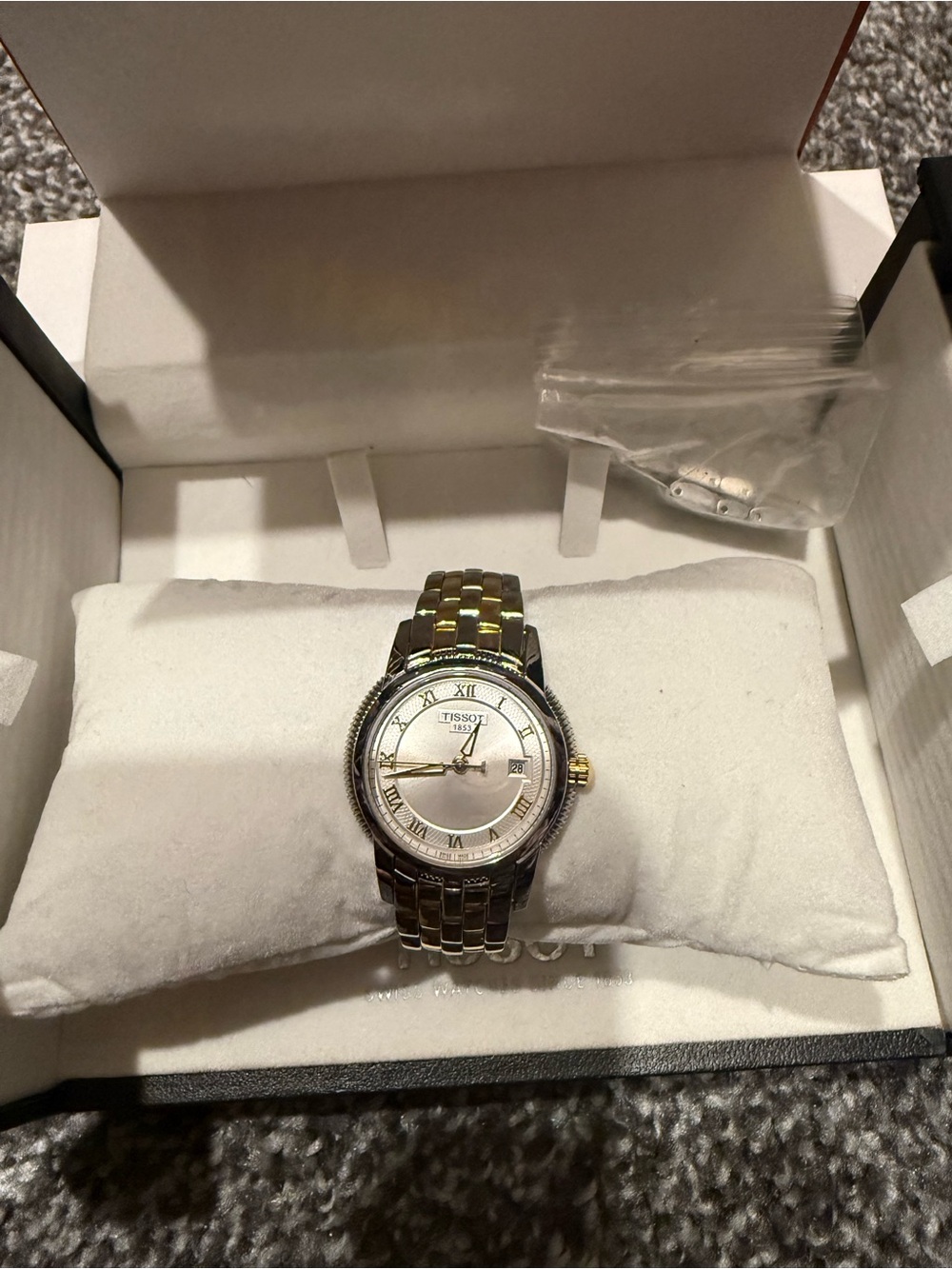 Tissot women’s watch in silver and gold tone with a classic Roman numeral dial.